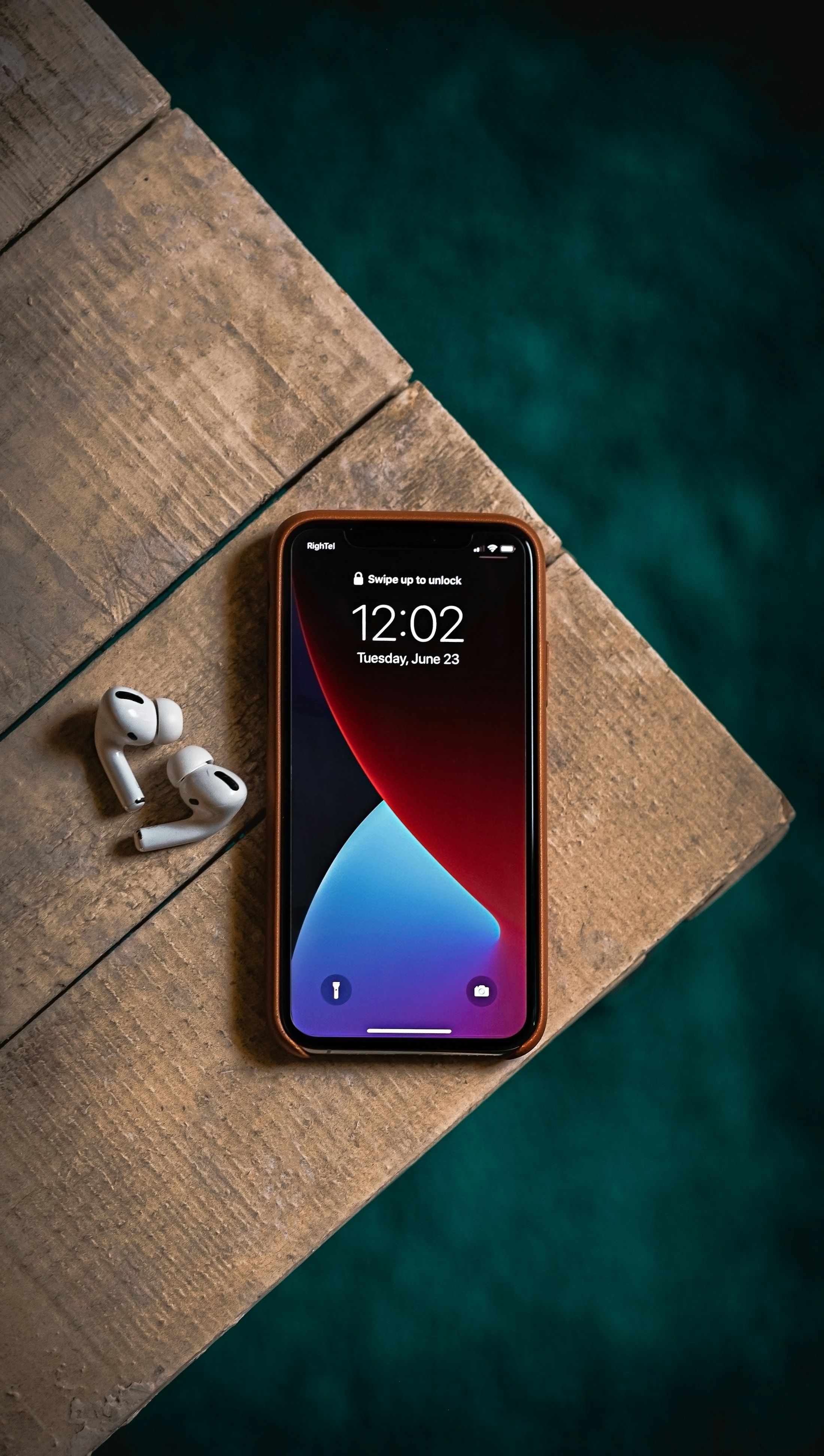 Celular e fones de ouvido sobre uma mesa de madeira