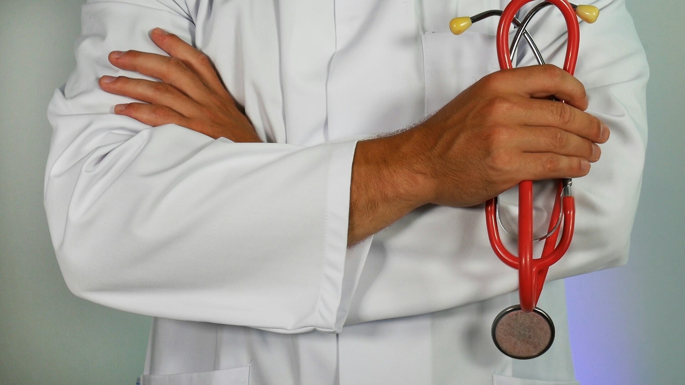 Médica de jaleco segurando um estetoscópio